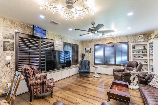 living room featuring light wood-type flooring and a textured ceiling