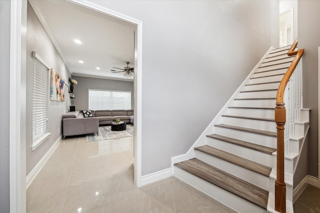 stairs with ceiling fan and ornamental molding