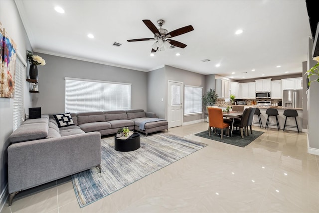 living room with ceiling fan and ornamental molding