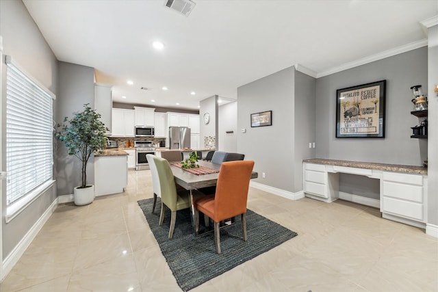 dining area with built in desk, sink, and ornamental molding