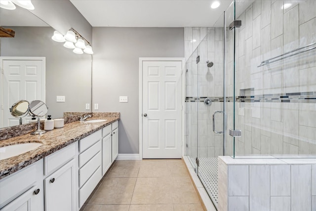 bathroom with an enclosed shower, vanity, and tile patterned floors