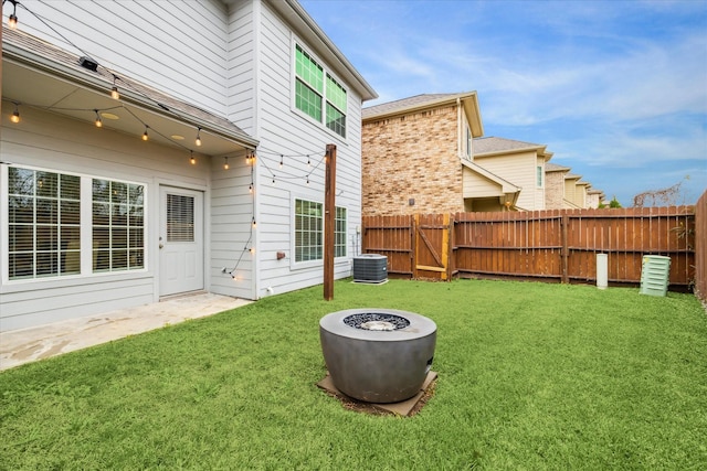 view of yard with central air condition unit and an outdoor fire pit