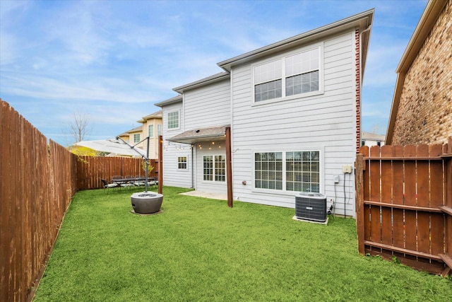 back of house featuring central AC and a yard