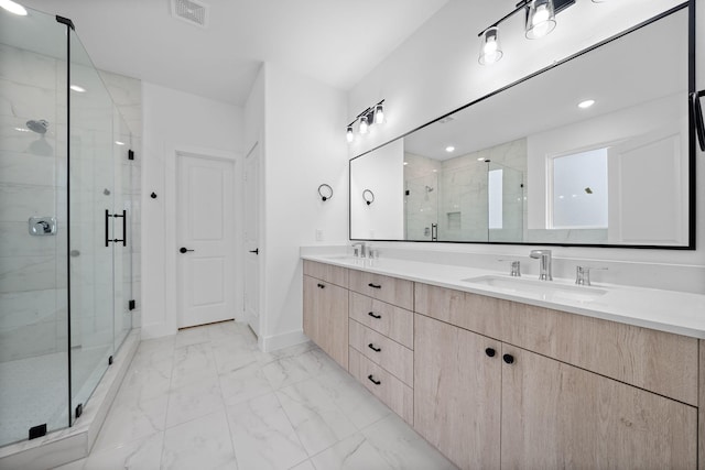 bathroom featuring a shower with shower door and vanity