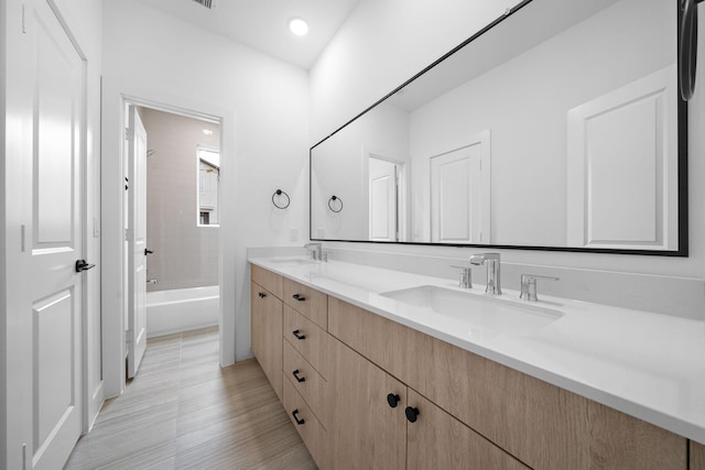 bathroom with vanity and tiled shower / bath