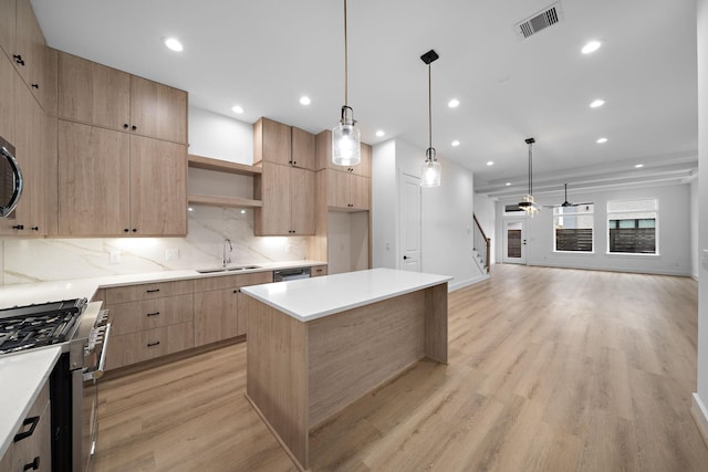 kitchen with decorative light fixtures, ceiling fan, appliances with stainless steel finishes, and sink