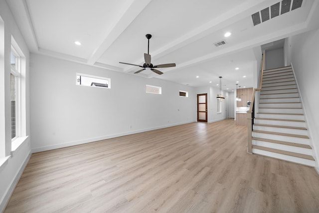 unfurnished living room with beam ceiling, ceiling fan, a wealth of natural light, and light hardwood / wood-style floors