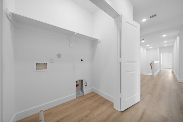 laundry room featuring washer hookup, light hardwood / wood-style floors, hookup for an electric dryer, and hookup for a gas dryer