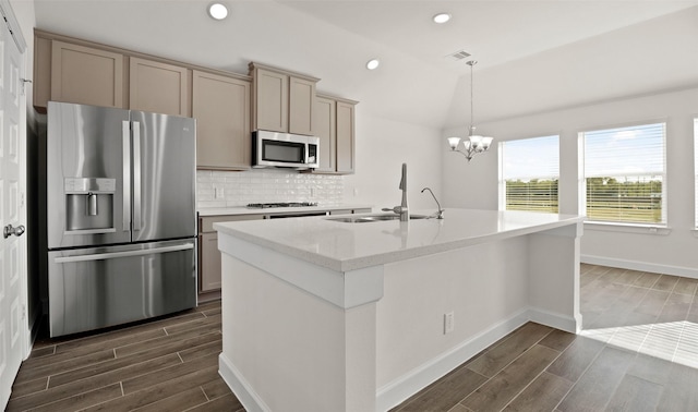 kitchen featuring tasteful backsplash, appliances with stainless steel finishes, wood finish floors, a sink, and recessed lighting