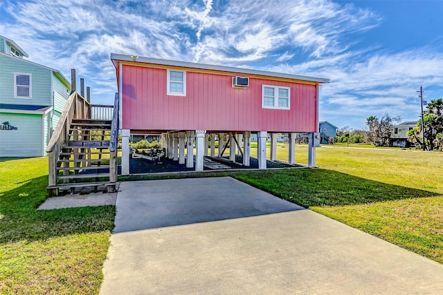 view of front facade with a front lawn, an AC wall unit, and a carport