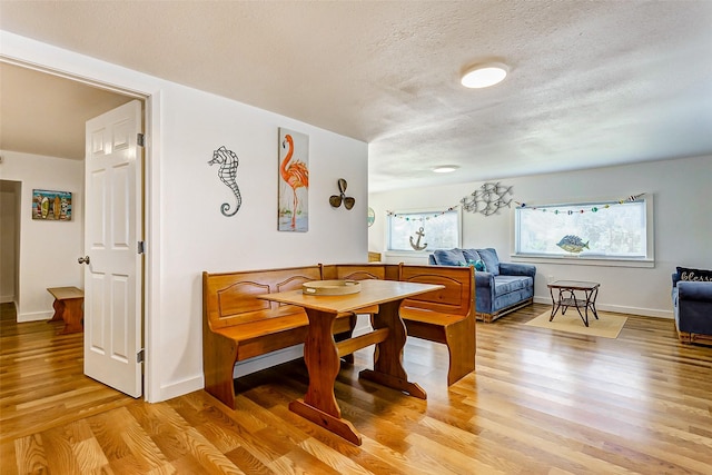 dining area featuring a textured ceiling and light wood-type flooring