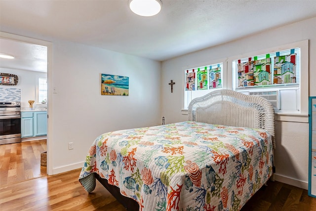 bedroom with cooling unit and light hardwood / wood-style flooring