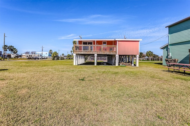 back of house featuring a wooden deck and a lawn