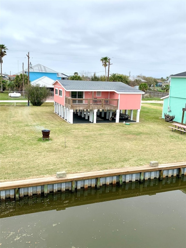 rear view of house with a yard and a water view