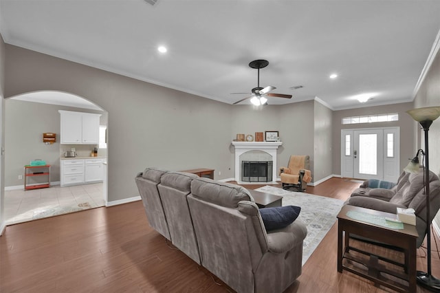 living room featuring ceiling fan, light hardwood / wood-style flooring, and crown molding