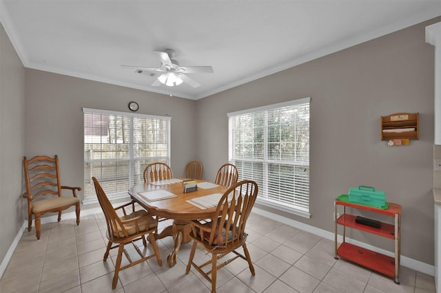 tiled dining area featuring ceiling fan and ornamental molding