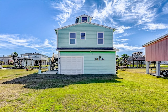 rear view of property featuring a yard and a garage