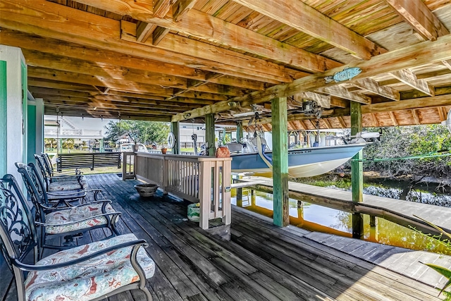 wooden deck featuring a boat dock and a water view