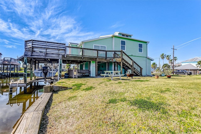 rear view of property with a lawn and a deck with water view