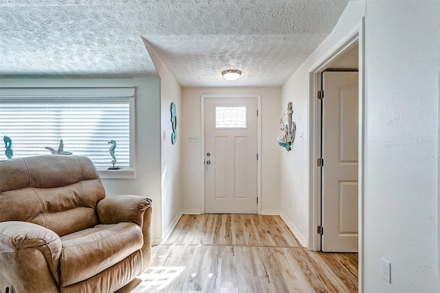 entryway featuring a healthy amount of sunlight, light wood-type flooring, and a textured ceiling