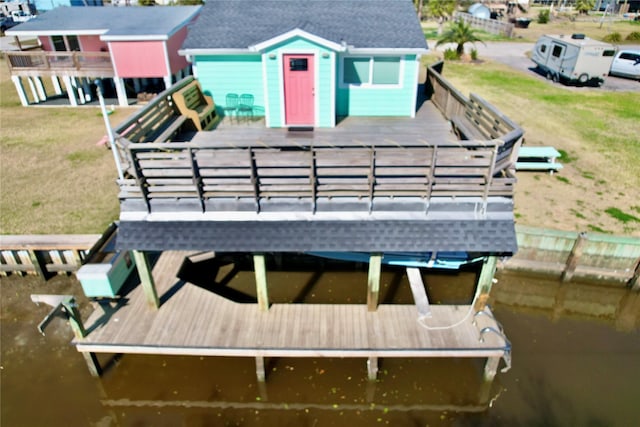 dock area featuring a lawn and a deck with water view