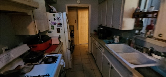 kitchen with gas range gas stove, sink, and light tile patterned flooring