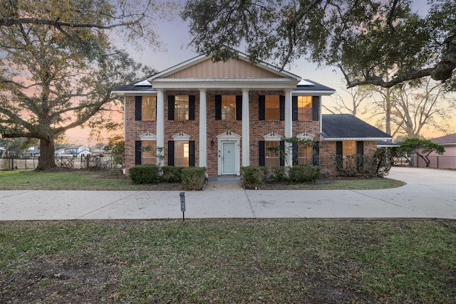 neoclassical / greek revival house featuring a yard