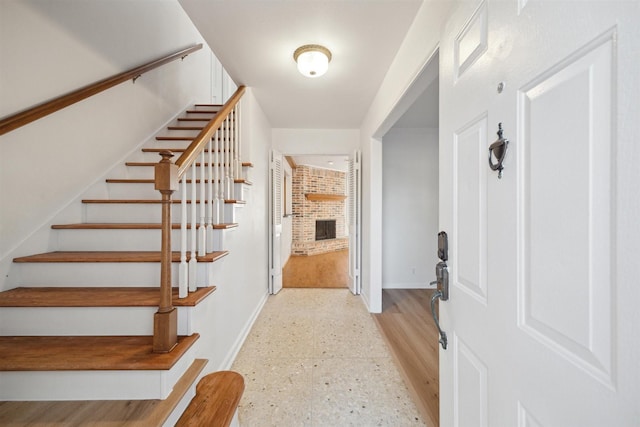 foyer featuring a brick fireplace