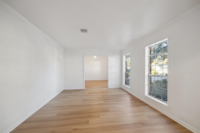 spare room featuring crown molding and light hardwood / wood-style floors