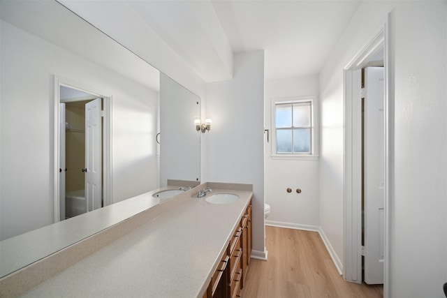 bathroom with hardwood / wood-style flooring, vanity, and toilet