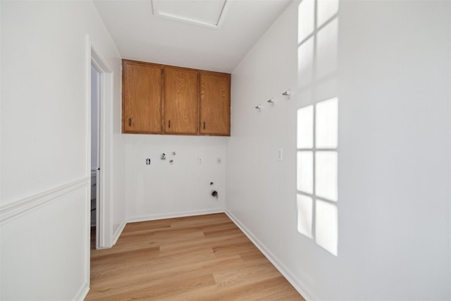 washroom featuring cabinets, hookup for an electric dryer, hookup for a washing machine, and light wood-type flooring