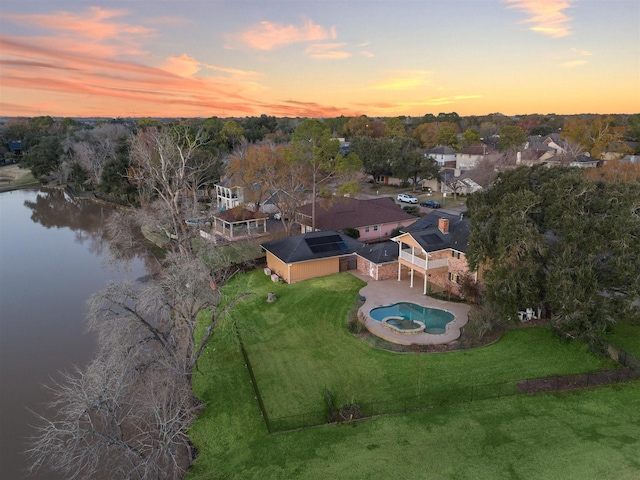 aerial view at dusk featuring a water view