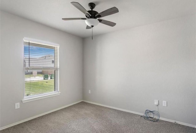 carpeted spare room featuring ceiling fan