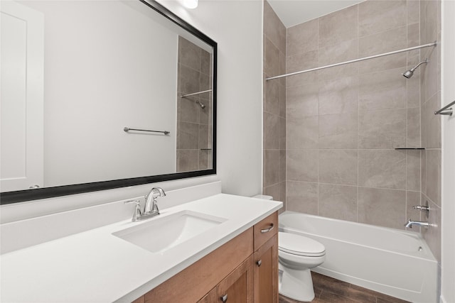 full bathroom featuring toilet, tiled shower / bath, and vanity