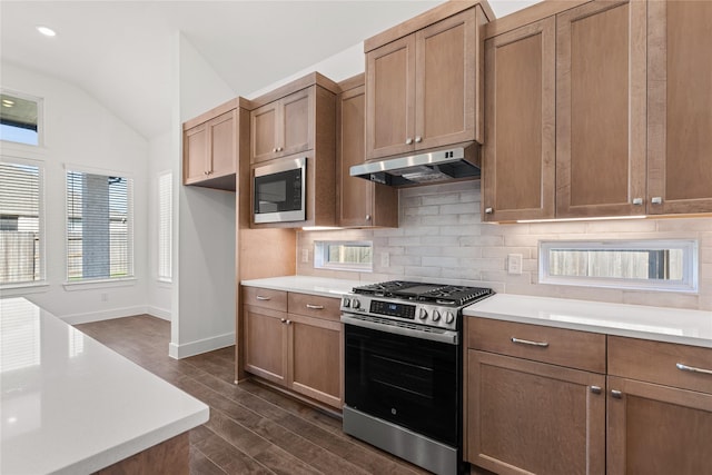 kitchen with vaulted ceiling, dark hardwood / wood-style floors, decorative backsplash, stainless steel range with gas cooktop, and built in microwave