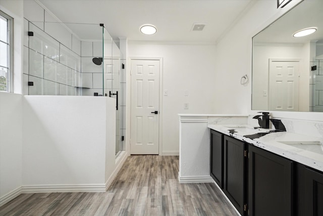 bathroom with wood-type flooring, an enclosed shower, vanity, and ornamental molding