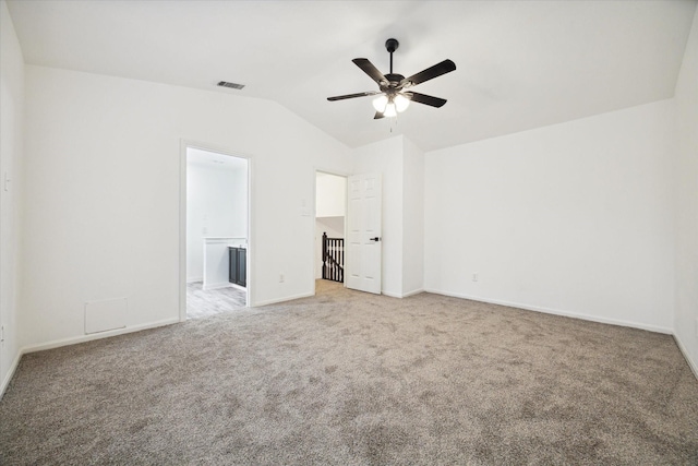 unfurnished bedroom with vaulted ceiling, ceiling fan, light colored carpet, and ensuite bath