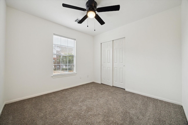 unfurnished bedroom featuring ceiling fan, a closet, and carpet flooring