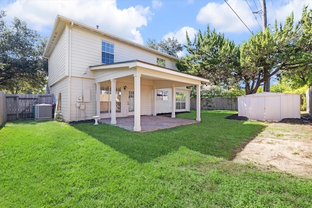 back of property featuring central air condition unit, a patio area, a storage shed, and a yard