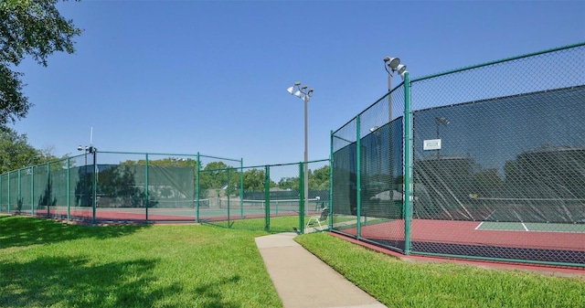 view of sport court with a lawn