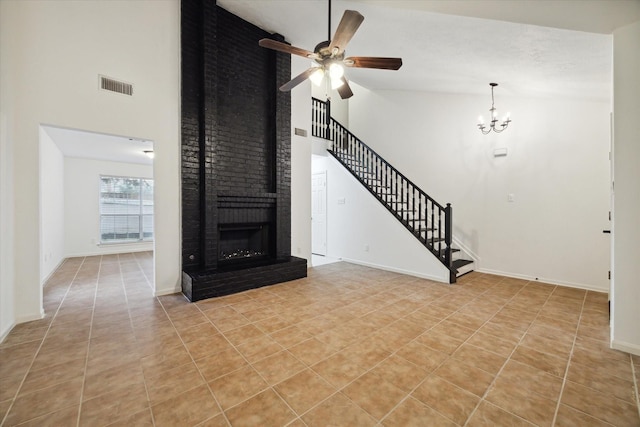 unfurnished living room with high vaulted ceiling, light tile patterned floors, a brick fireplace, and ceiling fan with notable chandelier