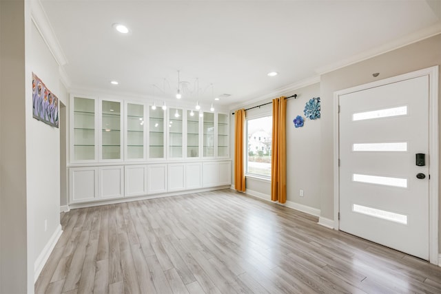 foyer featuring crown molding and light hardwood / wood-style floors