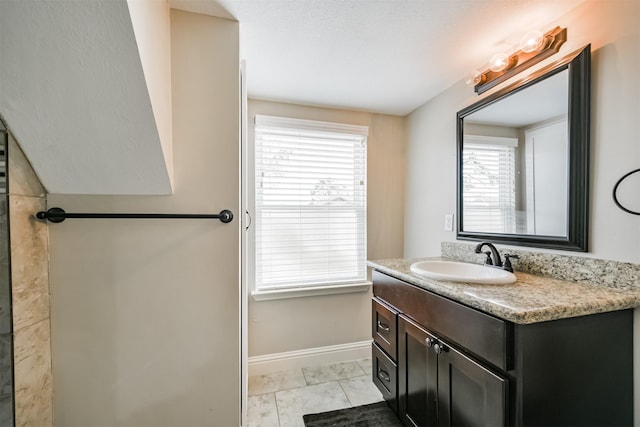 bathroom featuring a healthy amount of sunlight, tile patterned floors, and vanity