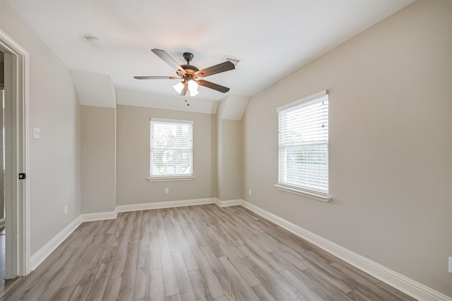 unfurnished room with lofted ceiling, ceiling fan, a healthy amount of sunlight, and light hardwood / wood-style flooring