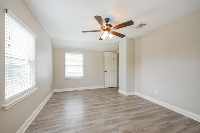 empty room featuring ceiling fan, plenty of natural light, and light hardwood / wood-style flooring