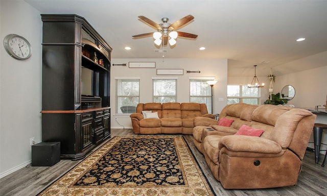 living room featuring wood-type flooring and ceiling fan with notable chandelier