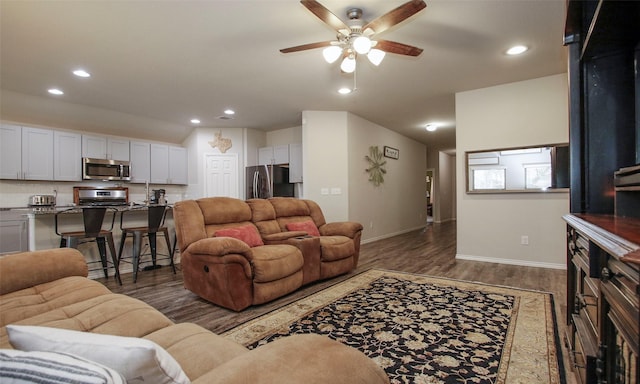 living room with ceiling fan and dark hardwood / wood-style flooring