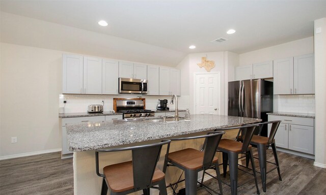 kitchen with white cabinetry, sink, stainless steel appliances, and a center island with sink