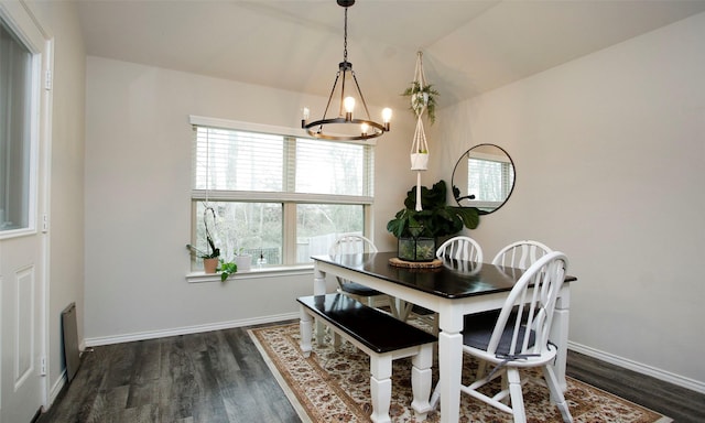 dining area featuring dark hardwood / wood-style flooring and an inviting chandelier