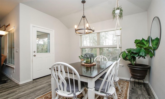 dining space with vaulted ceiling, dark wood-type flooring, and a chandelier